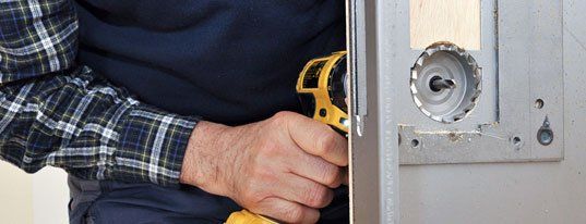 Handyman installing lock on door