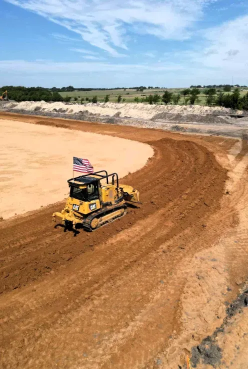A bulldozer is driving down a dirt road.