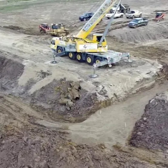 An aerial view of a construction site with a yellow crane.