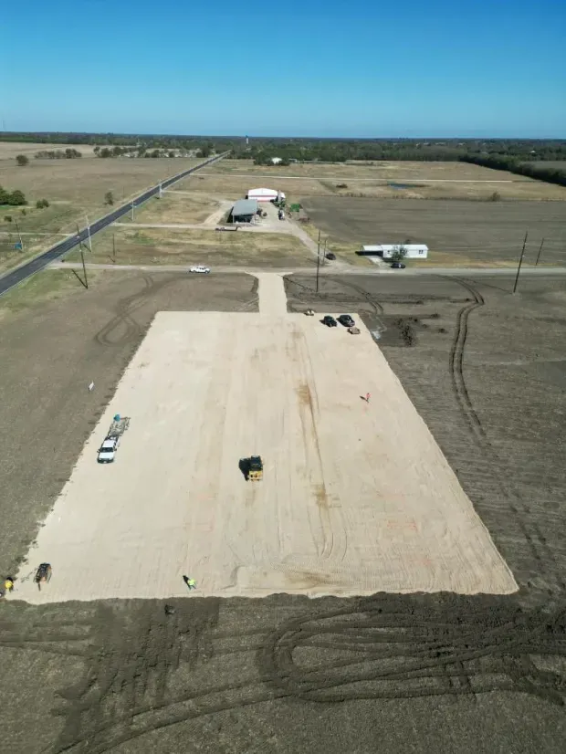 An aerial view of a dirt road going through a field