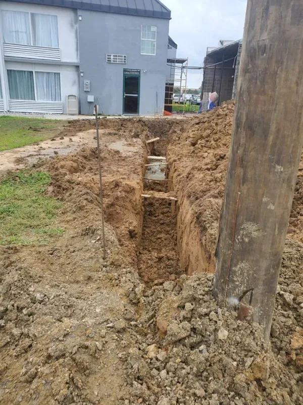 A large pile of dirt is in front of a house.