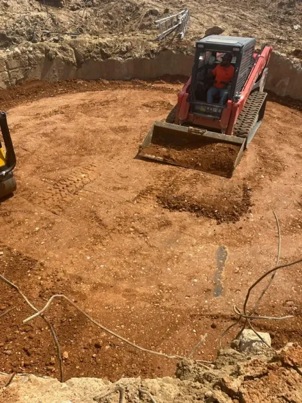 A bulldozer is moving dirt in a circle on a construction site.