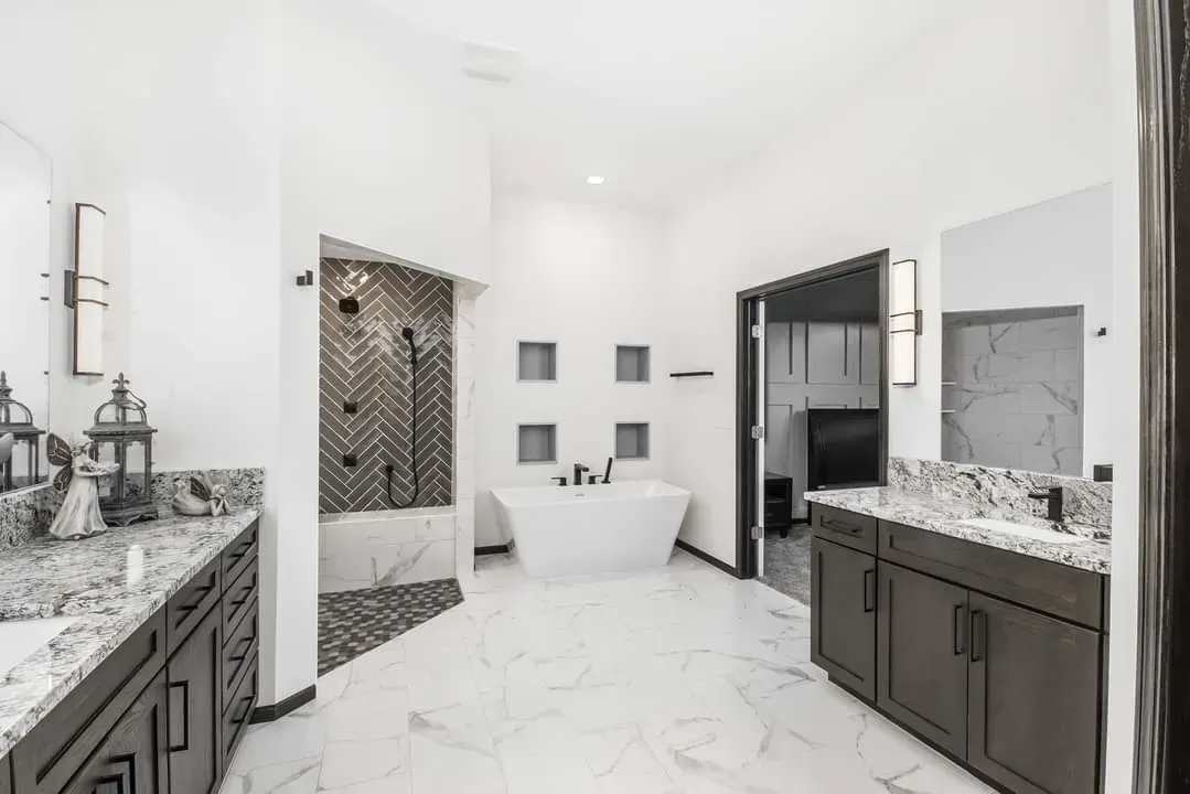 Bright modern bathroom with marble floors, double vanity, walk-in shower, and freestanding tub.