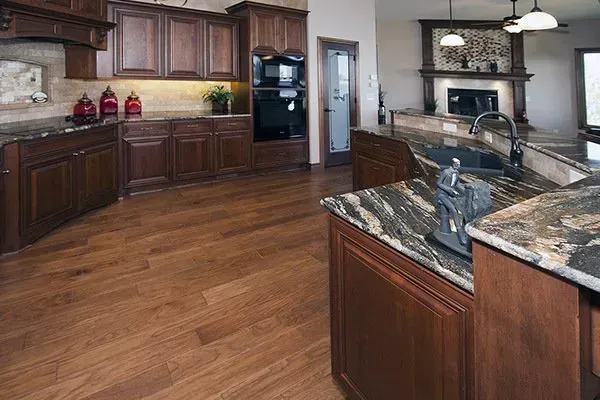 Spacious modern kitchen with dark wood cabinets, granite countertops, and hardwood floors