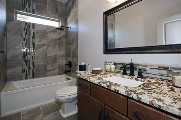 Modern bathroom with tub, glass shower, dark vanity, and large mirror