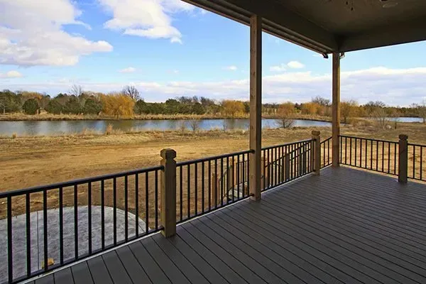 Covered deck overlooking a river and grassy bank under a blue sky