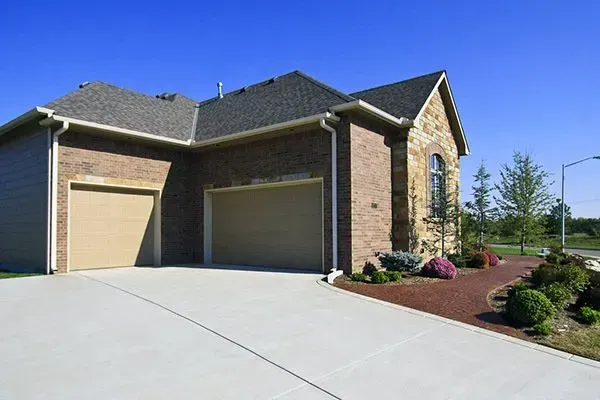 Modern suburban house with a two-car garage, concrete driveway, and landscaped front yard