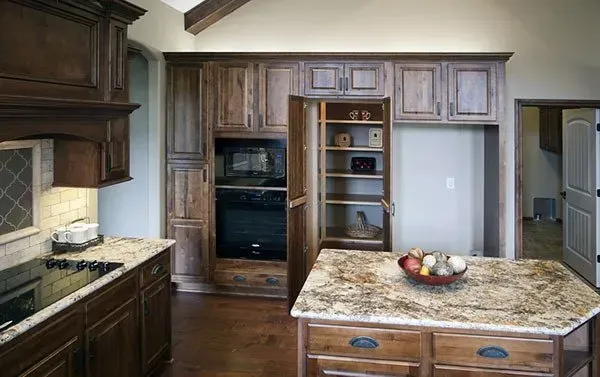 Modern kitchen with dark wood cabinets, granite island, and stainless appliances
