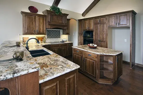 Modern kitchen with wood cabinets, granite island, stainless sink, and dark hardwood floors
