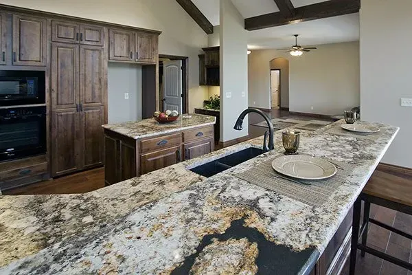 Modern kitchen with dark wood cabinets, granite island, and stainless steel appliances