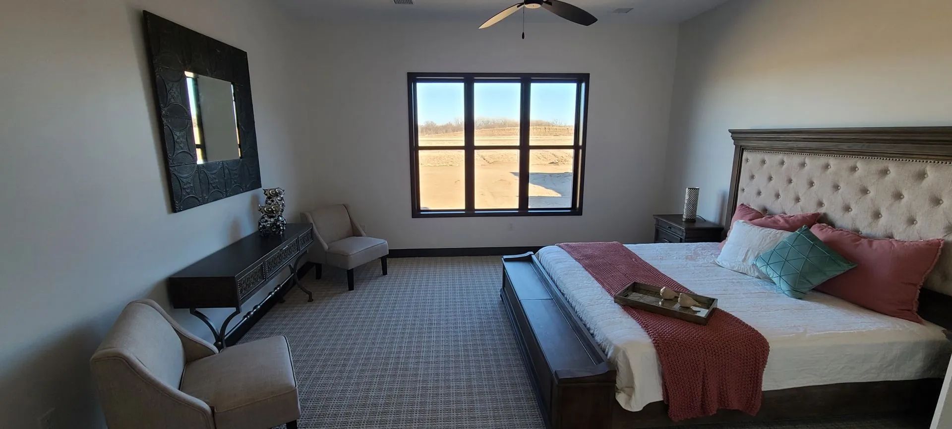 Modern bedroom with bed, dresser, window, and neutral decor in a bright room