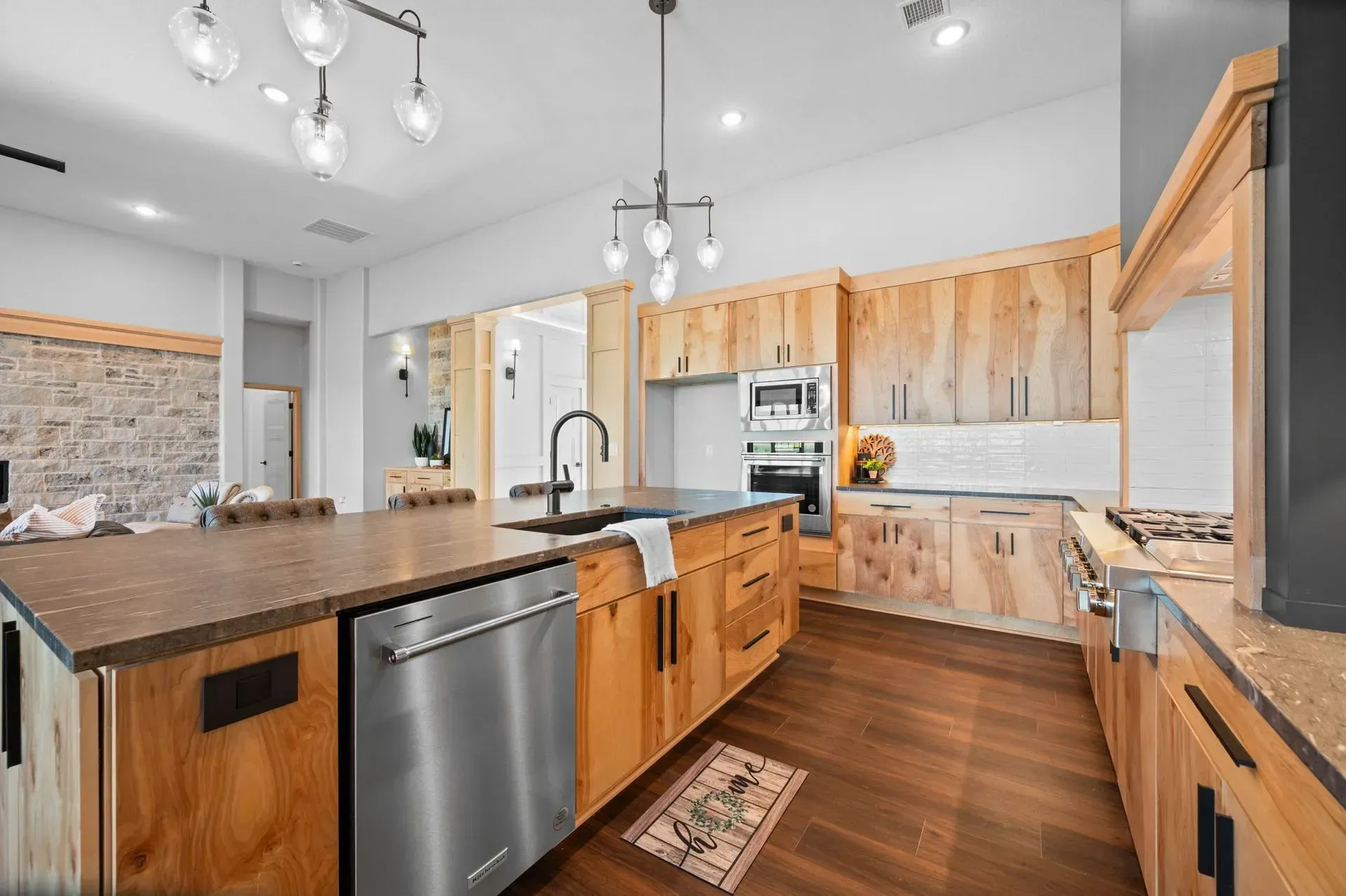 Modern kitchen with wood cabinets, stainless appliances, island, and hardwood floors
