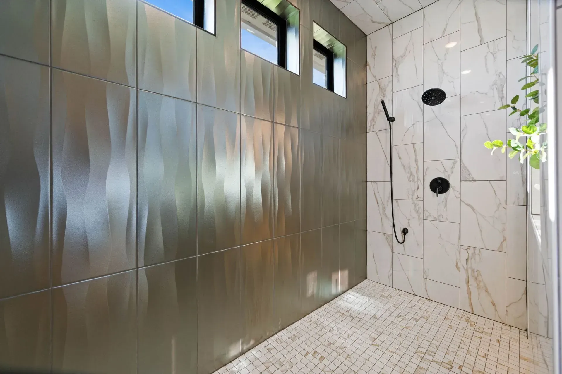 Modern shower with marble tile, metallic wall panels, and small high windows.