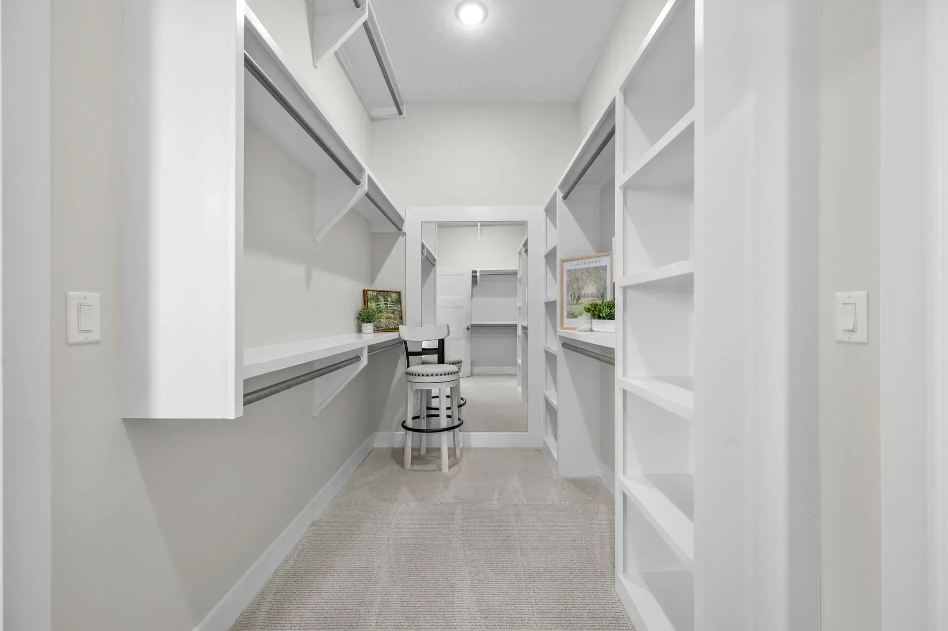 Bright white hallway with built-in shelves, a desk nook, and a chair at the far end