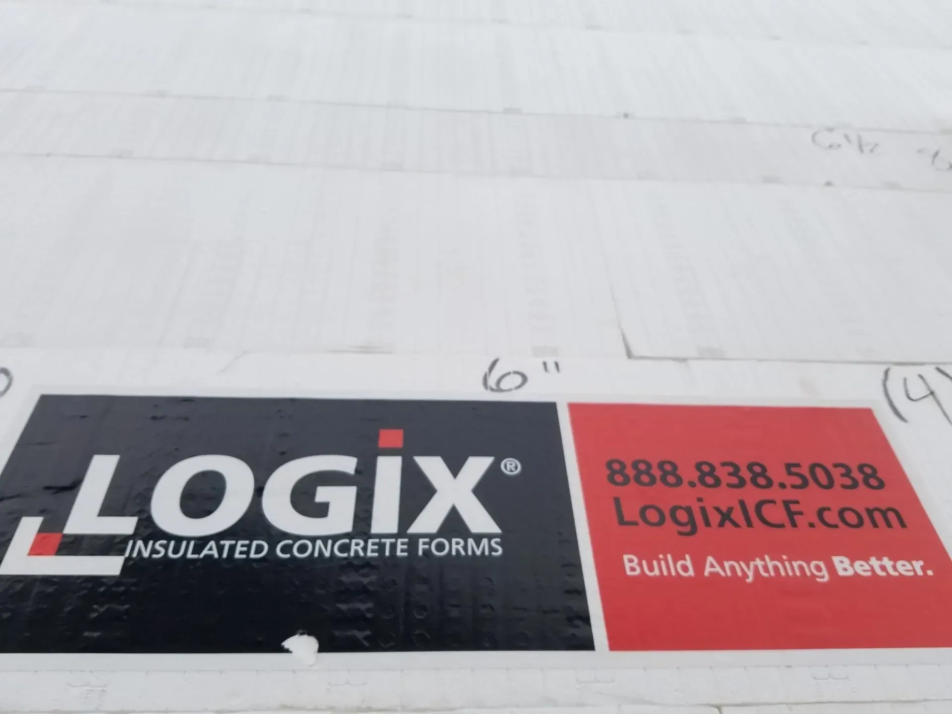 LOGIX insulated concrete forms sign on a white construction surface with red contact info panel