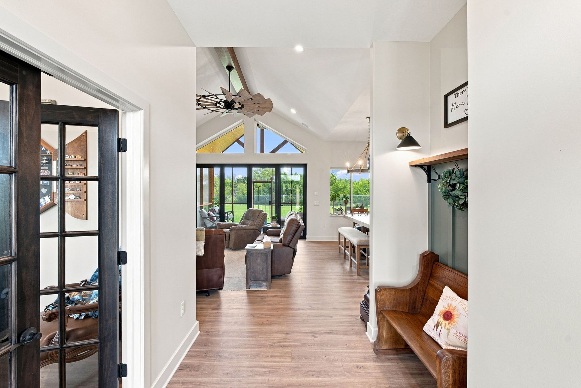 Bright open living room with wood floors, white walls, and sliding glass doors to a patio.