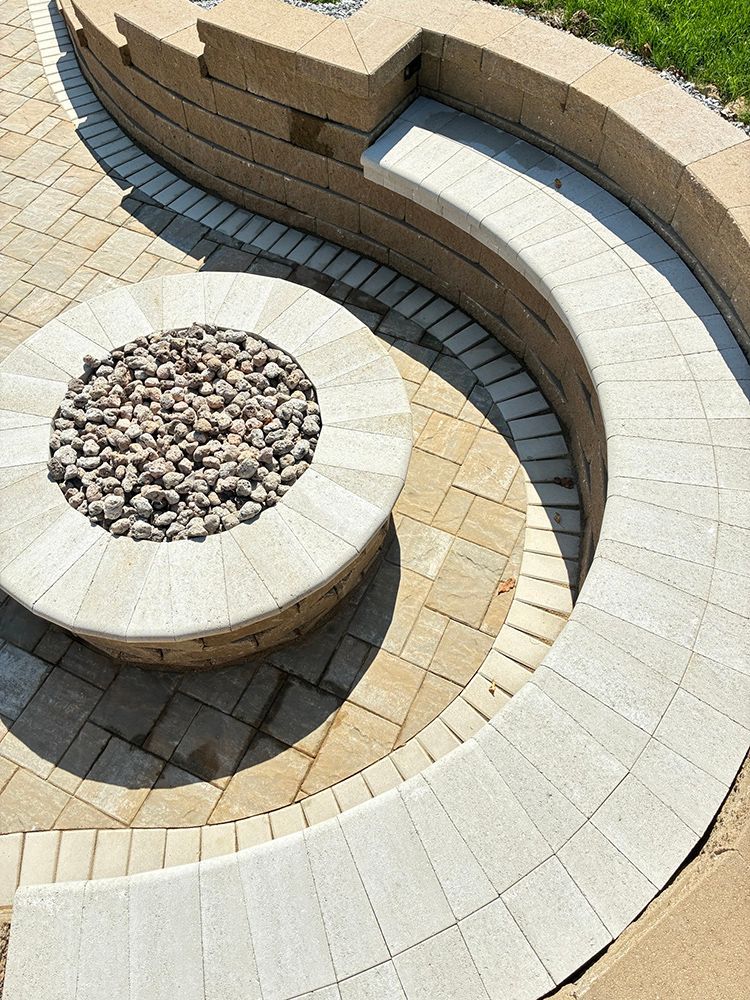 Circular fire pit with stone seating on a paved patio.