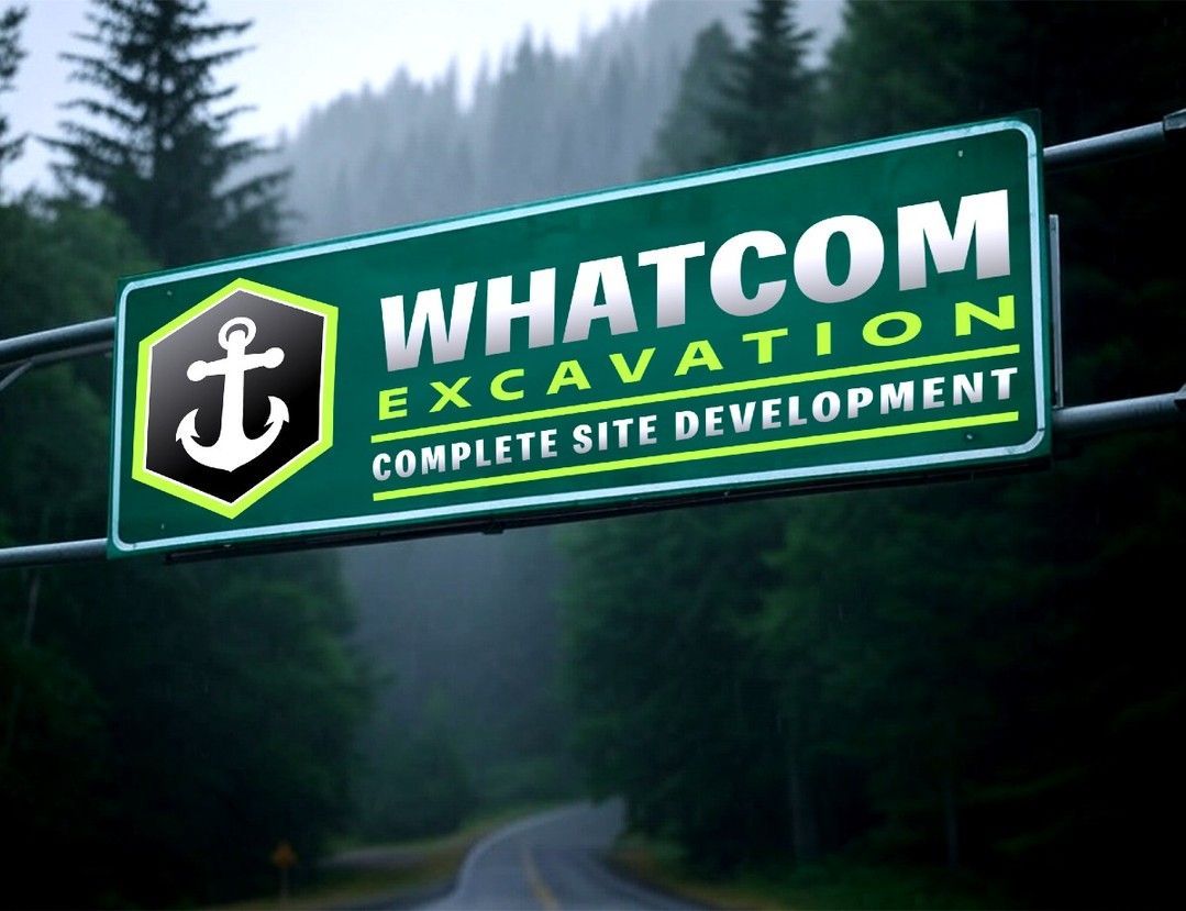 Sign for Whatcom Excavation, green and white, with an anchor logo, over a road in a forested area.