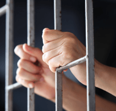 Hand in prison bars