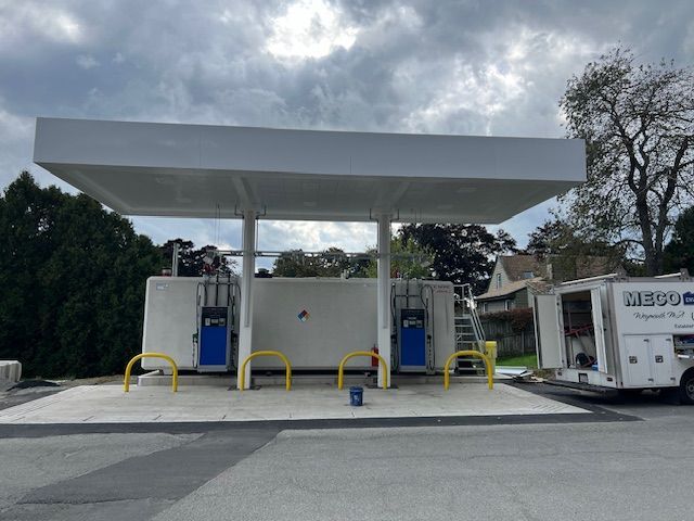 A gas station with a white building and yellow handles