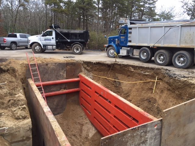 A truck with a red metal pipe in the middle of a pit