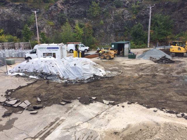 A construction site with a pile of debris and a truck