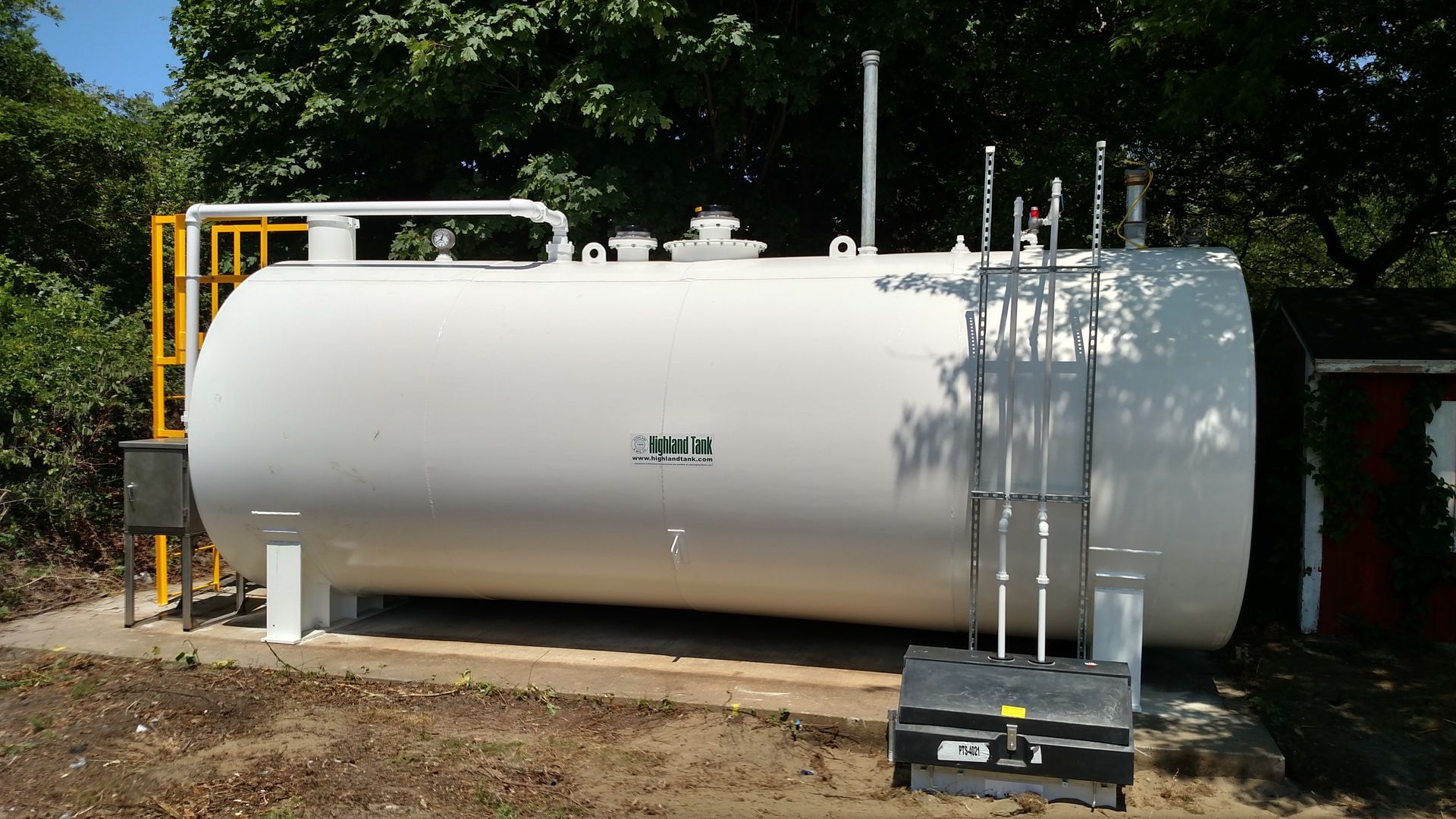 A large white tank with pipes and a black box