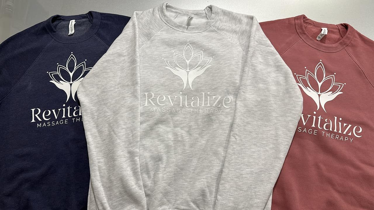 Three sweatshirts: navy, gray, and maroon, with a white logo and