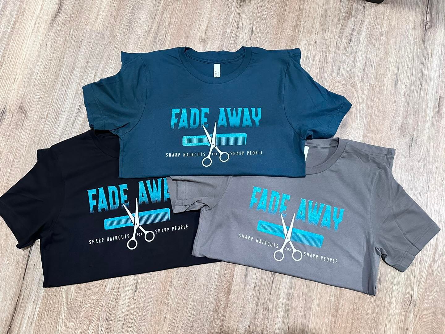 Three t-shirts: black, teal, and gray. Each with 