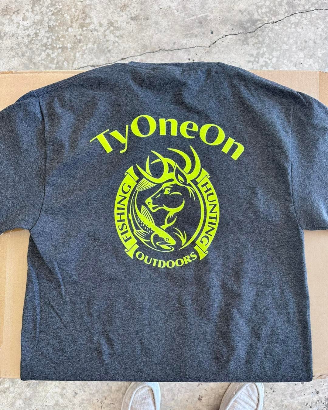 Dark gray t-shirt with a neon green logo: 
