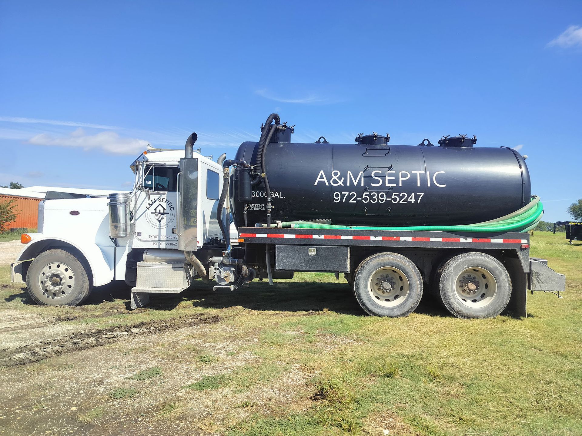White septic truck with black tank, A&M Septic, parked on grass, blue sky.