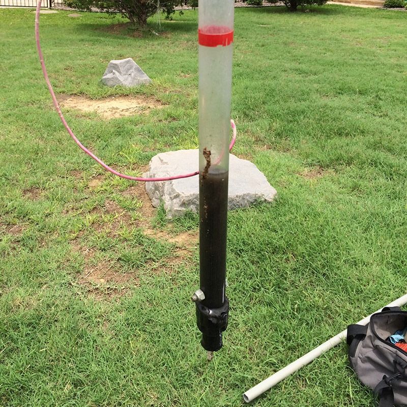 Clear tube with soil sample extracted from the ground.
