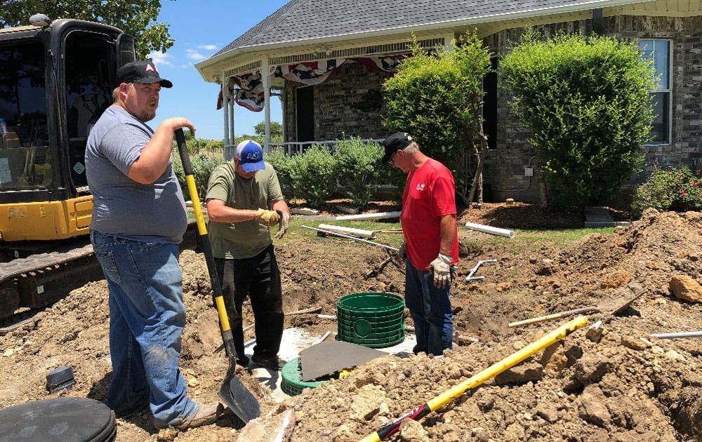 A&M Septic truck, white cab and black tank, parked outdoors. Phone number 972-539-5247 visible.