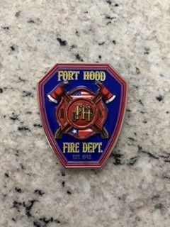 Fort Hood Fire Dept. blue and red badge patch with crossed axes on a speckled surface