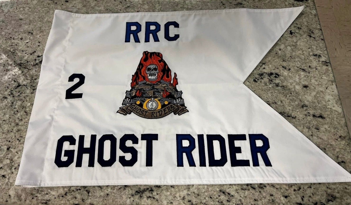 White pennant with navy text “RRC” and “GHOST RIDER,” number 2, and a red skull emblem