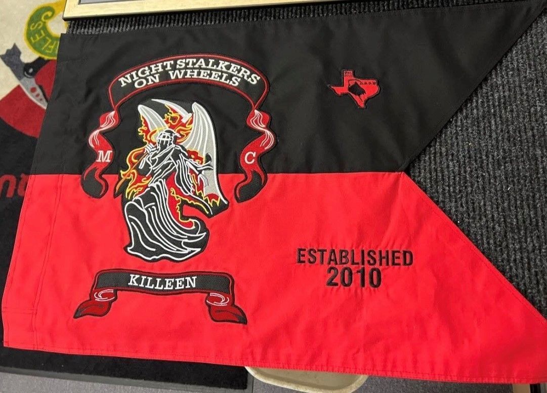 Black and red flag with a lion crest and “Established 2010” text