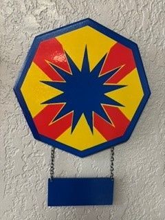 Octagonal red, yellow, and blue wall sign with a blue starburst and hanging blue plaque