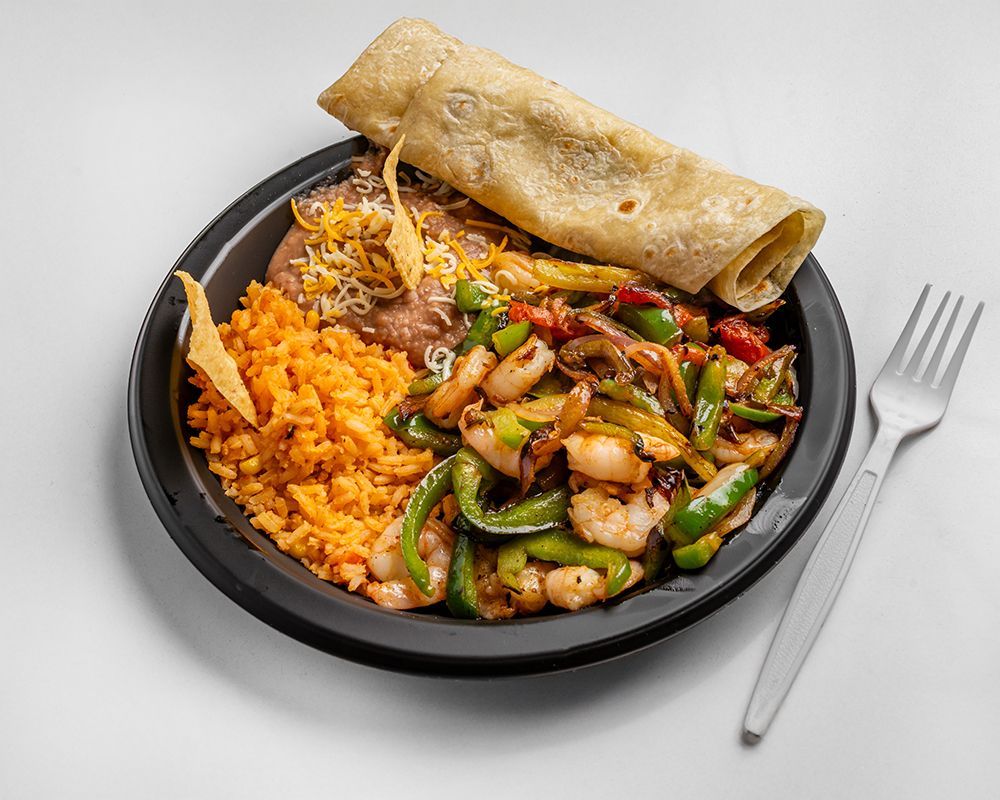 Plate of food with shrimp fajitas, rice, beans, and a tortilla.