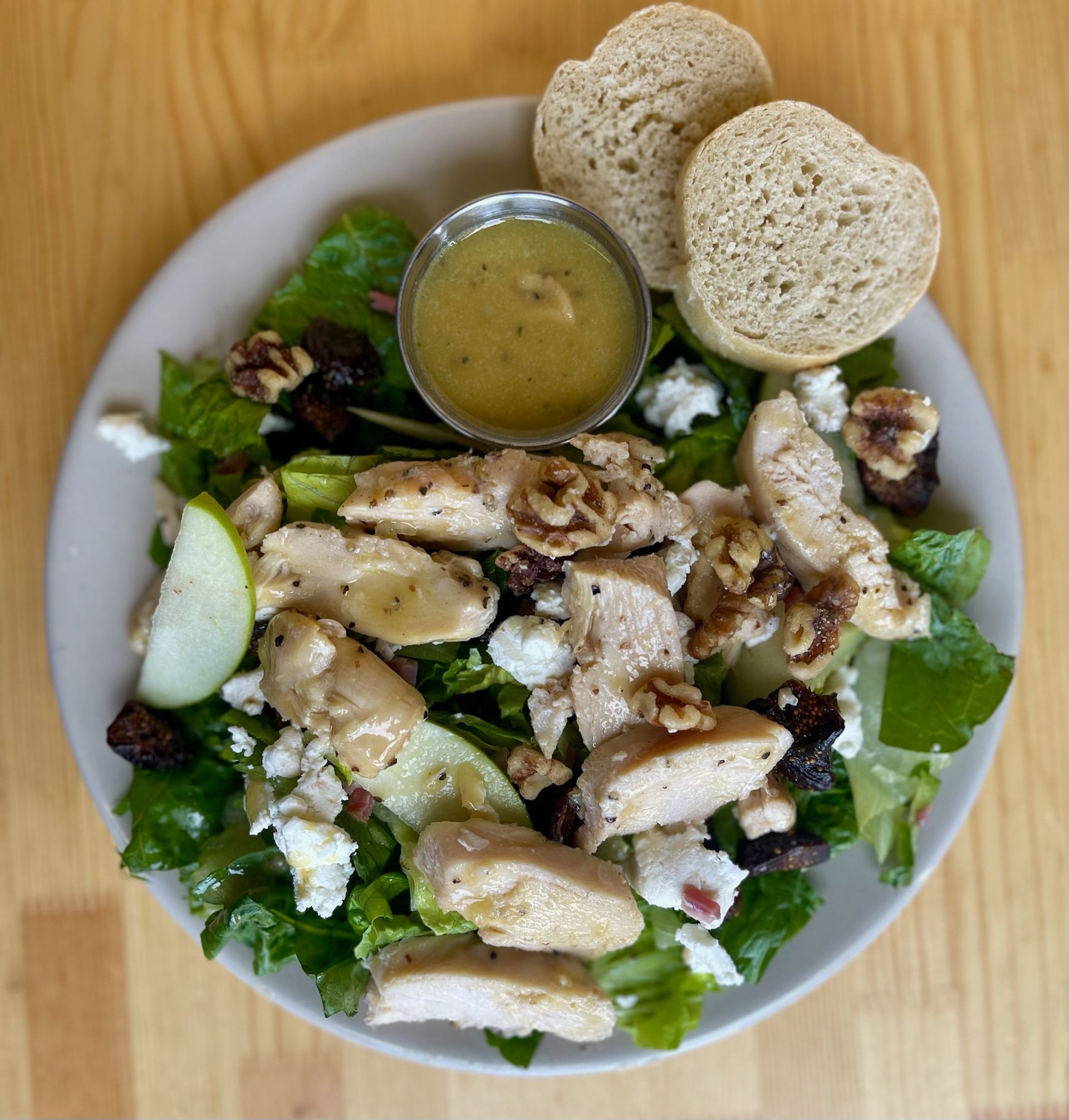 A white plate topped with a salad and bread