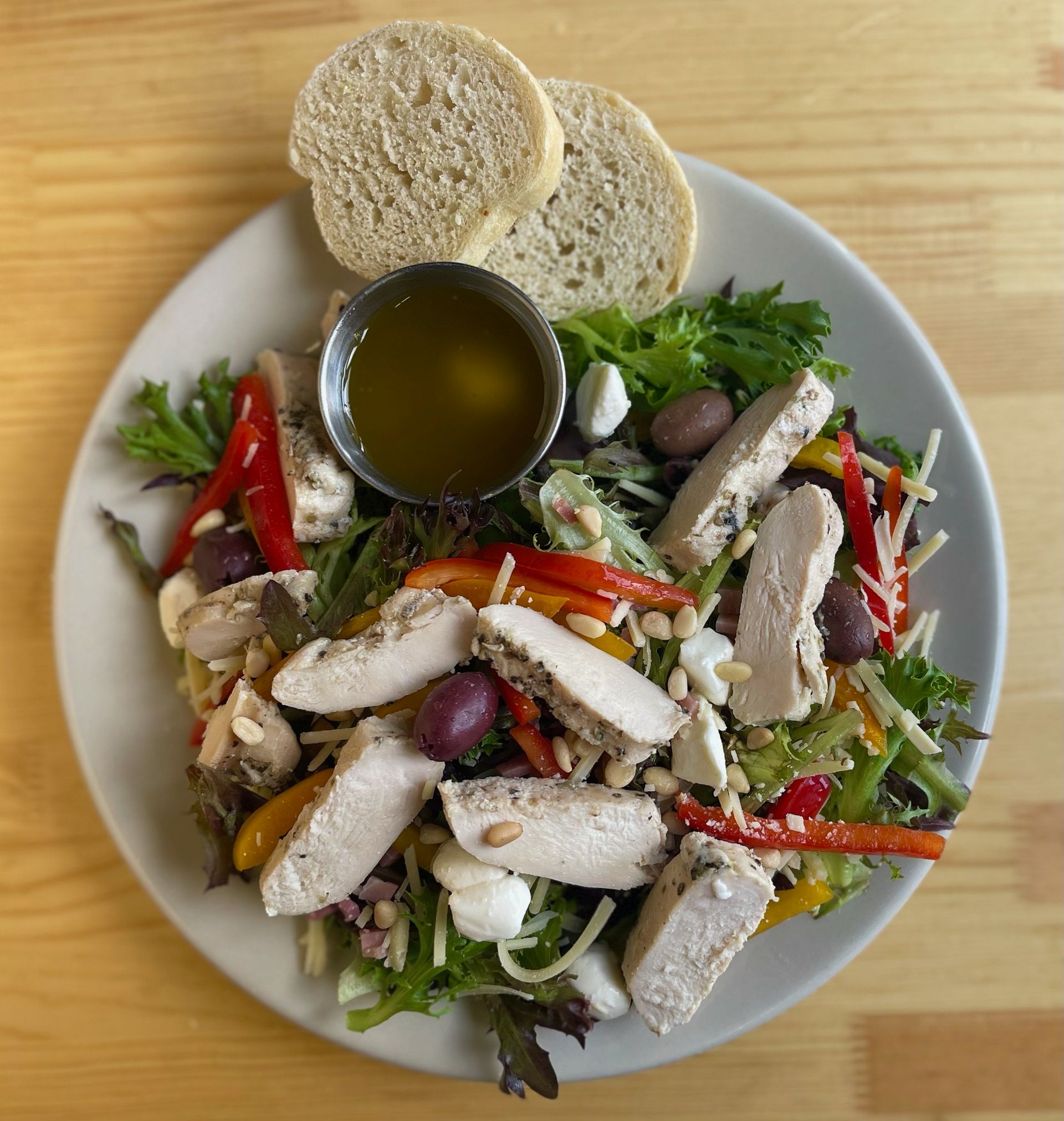A salad with chicken olives and bread on a plate