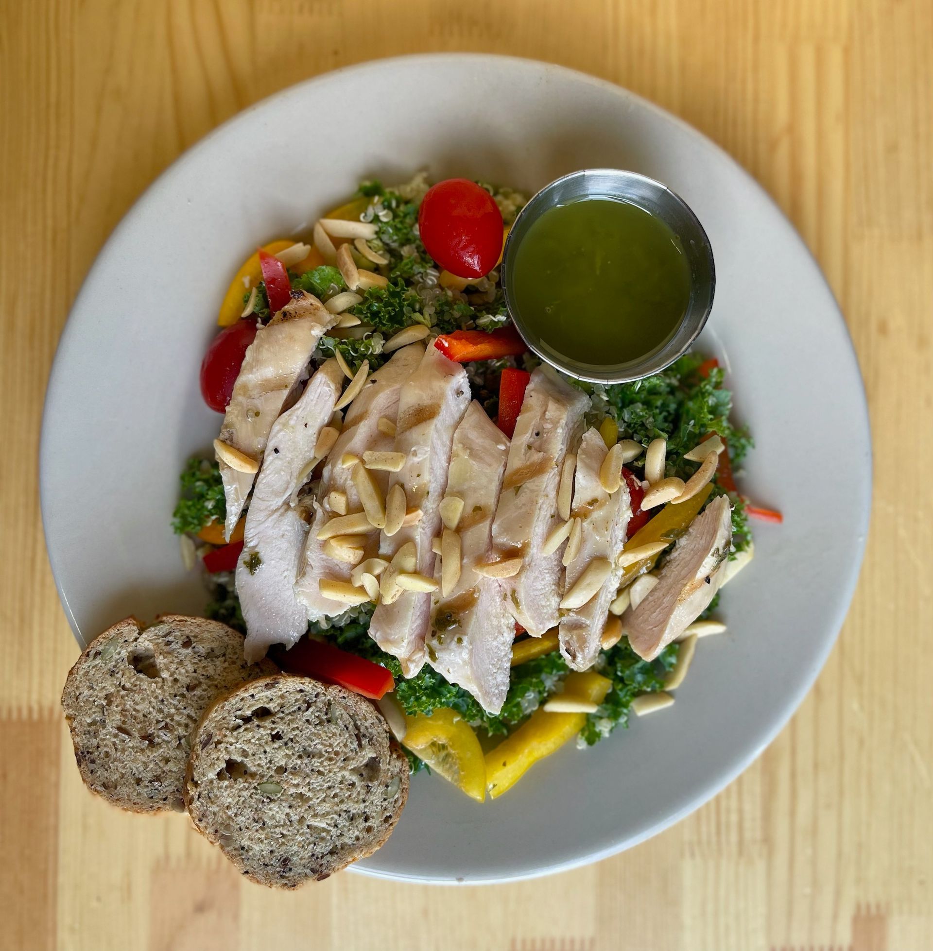 A white plate topped with chicken and vegetables with a dressing