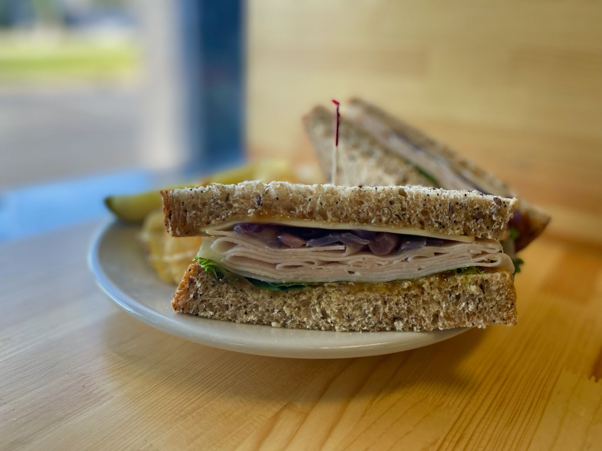 A sandwich on a plate on a wooden table.