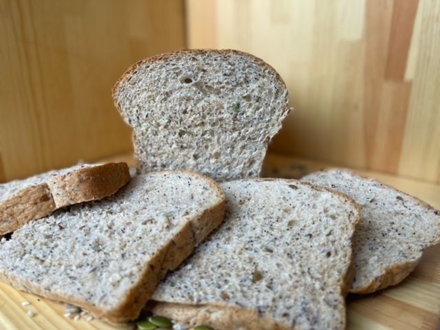A loaf of bread is sitting on top of a wooden cutting board.