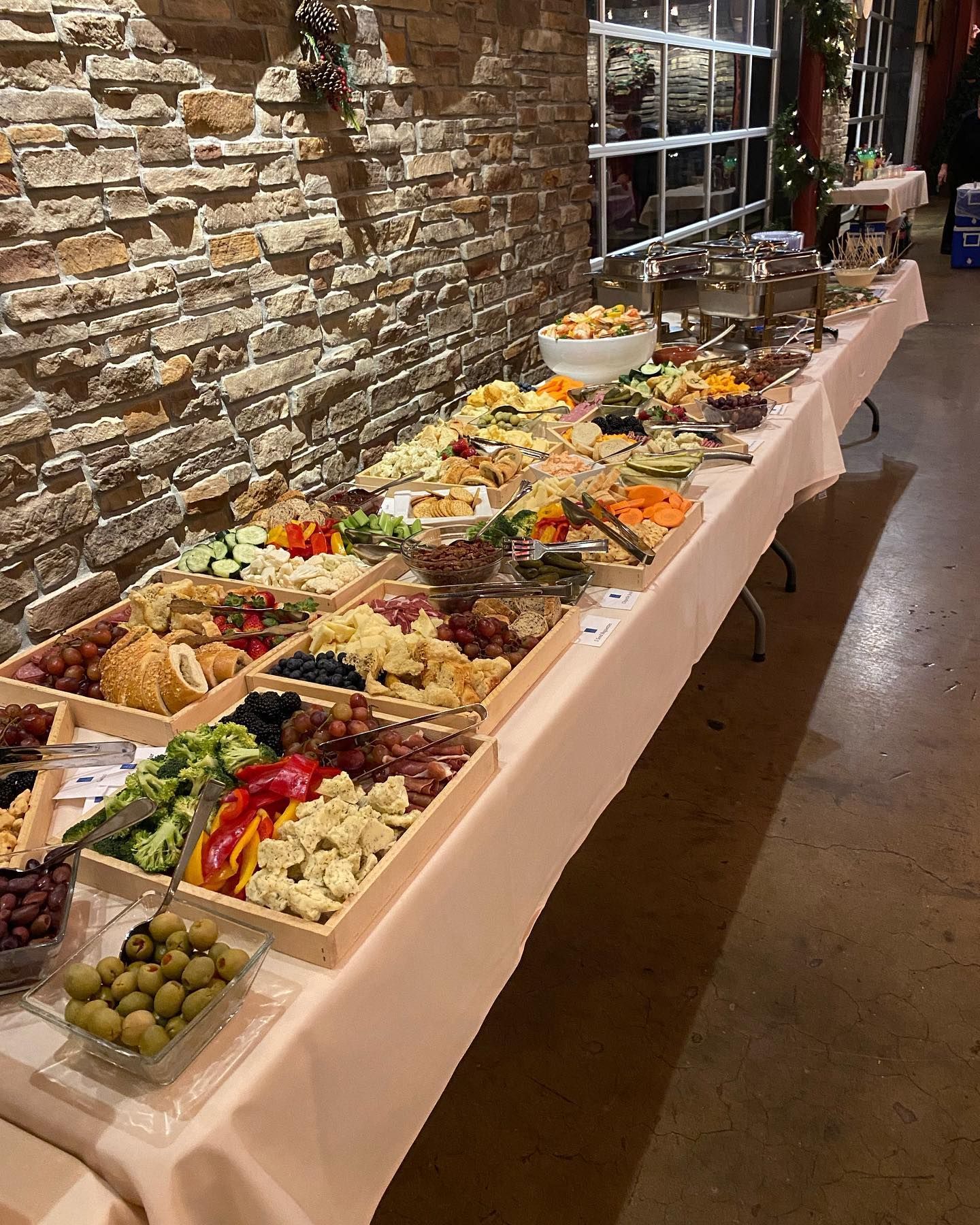 A long buffet table filled with lots of food and vegetables.