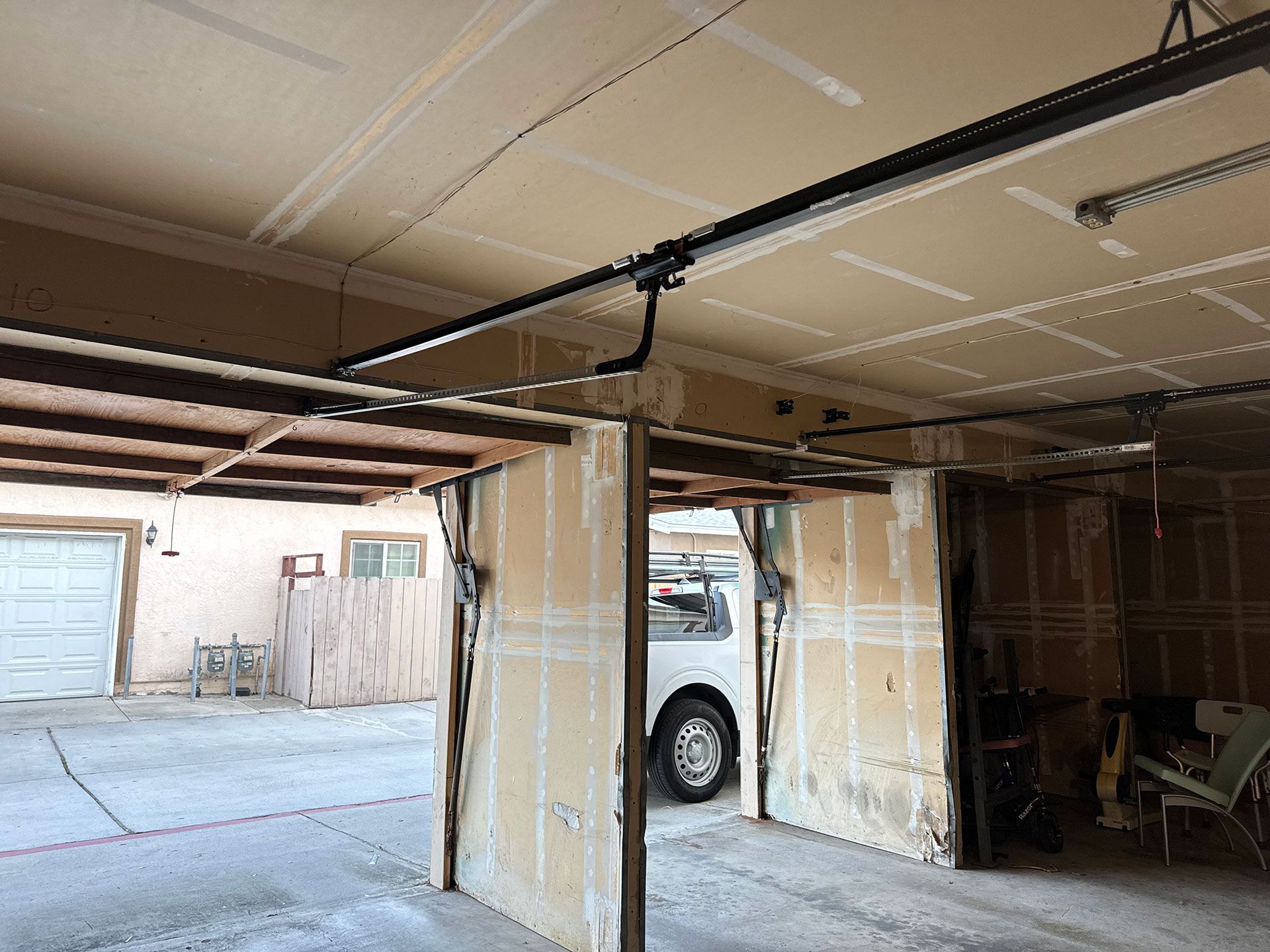 Garage interior with exposed walls and a car visible. The garage door track is overhead.