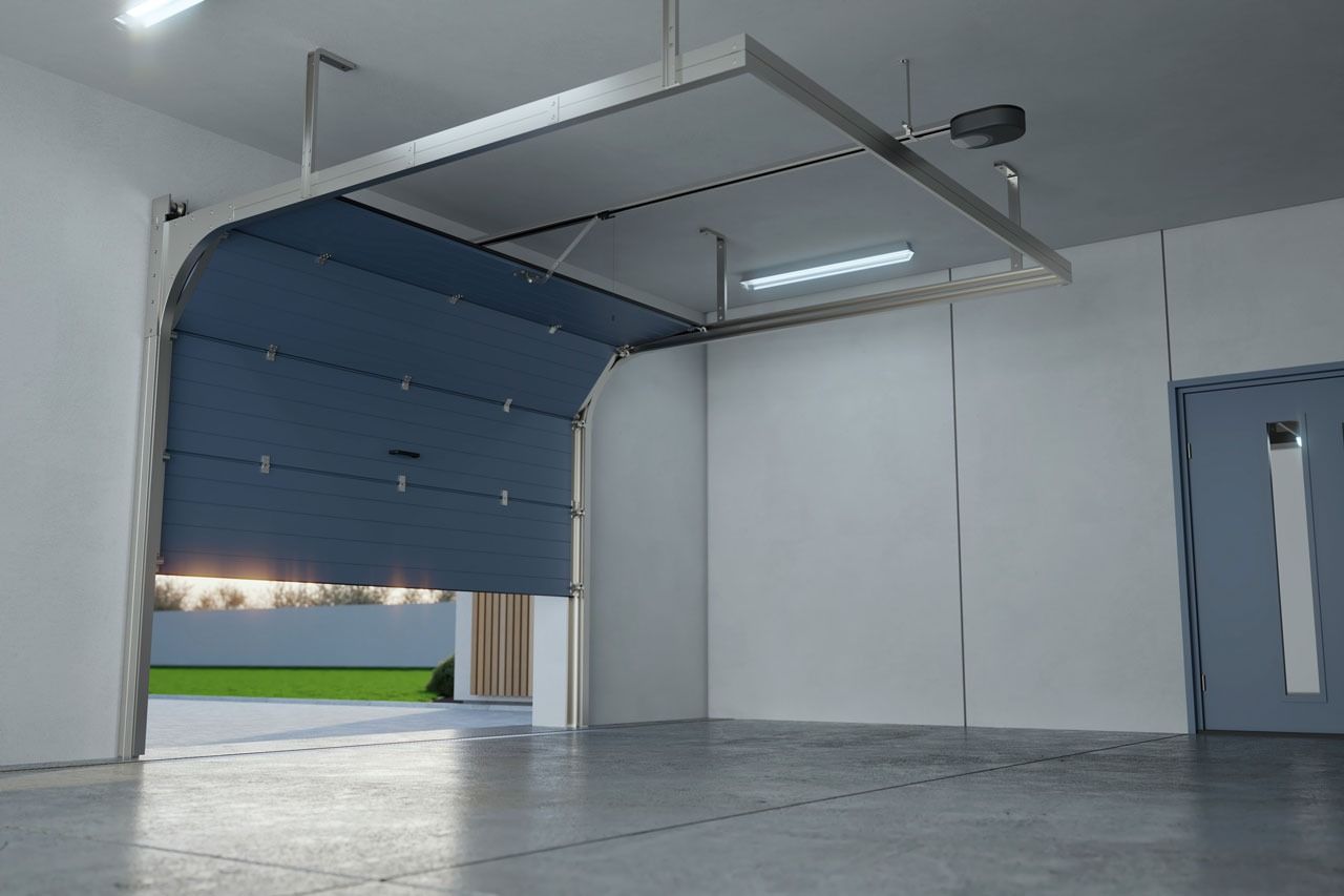 Blue garage door opening, revealing a yard; interior view with white walls and overhead light.