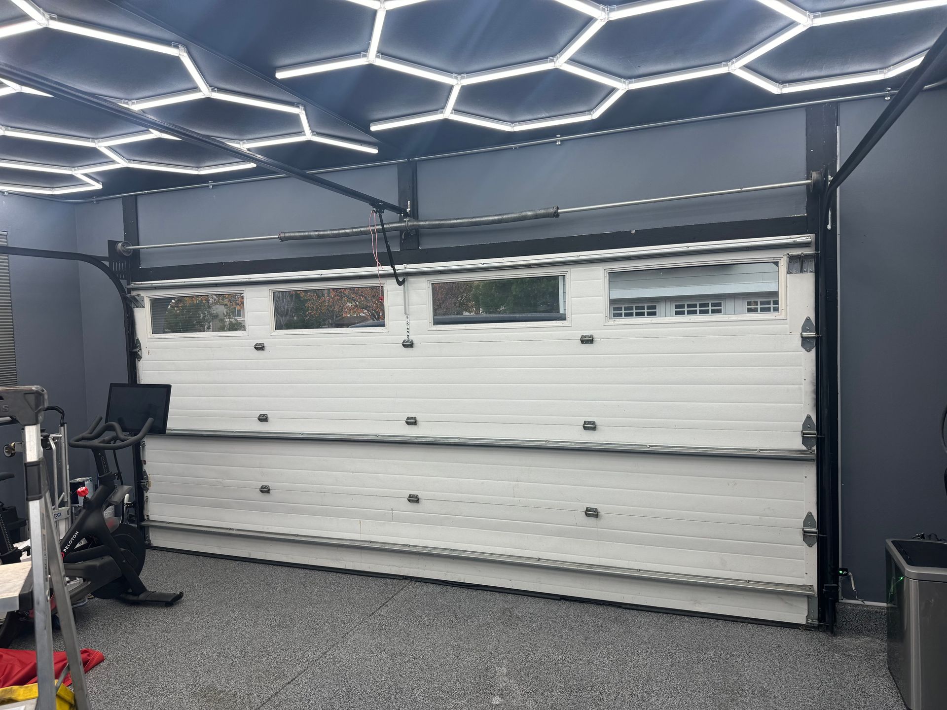 White garage door with windows, inside a room with hexagonal lights.