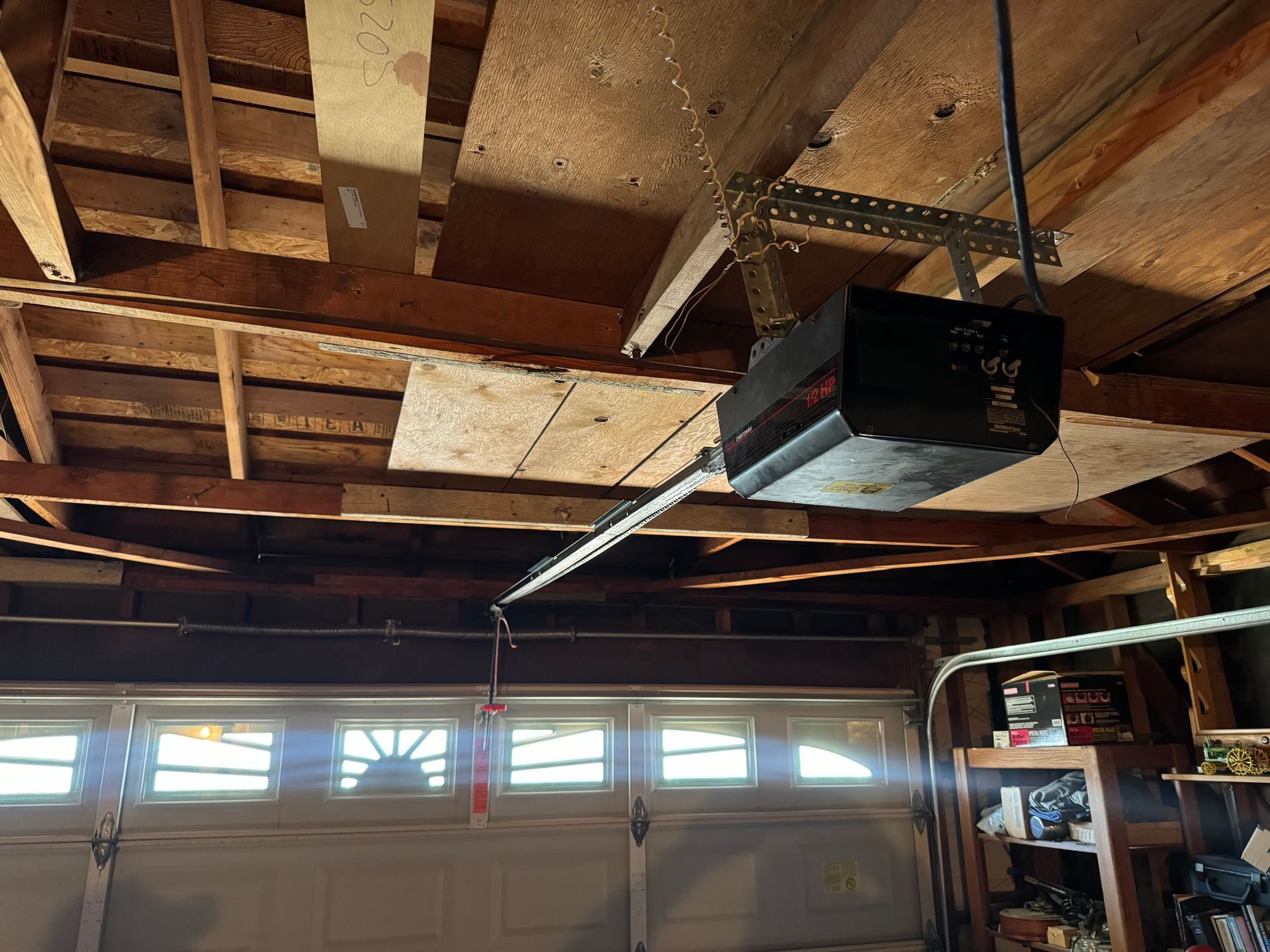 Garage ceiling with an overhead garage door opener. The door is closed.