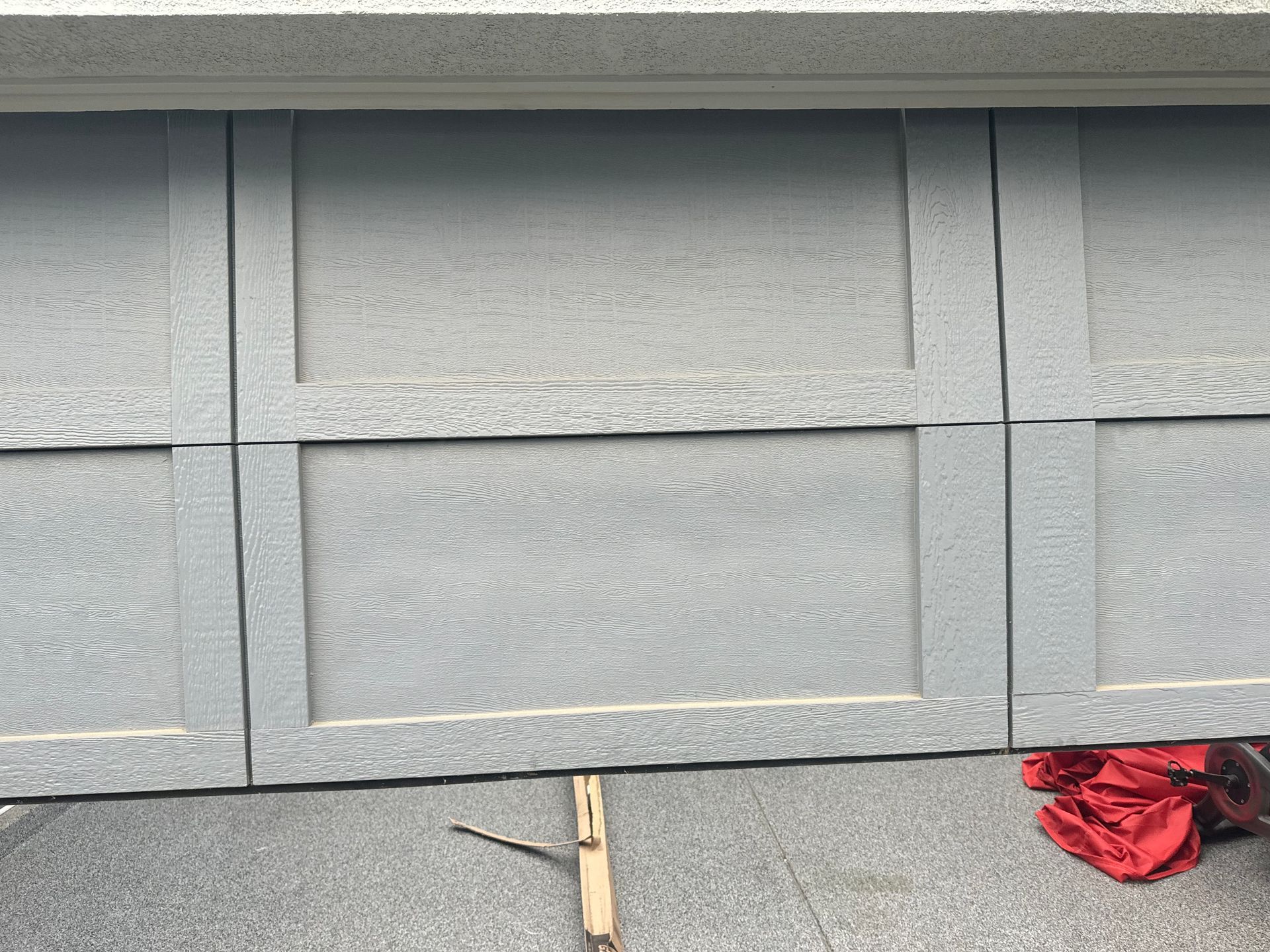 Gray garage door with paneled design; weathered look.