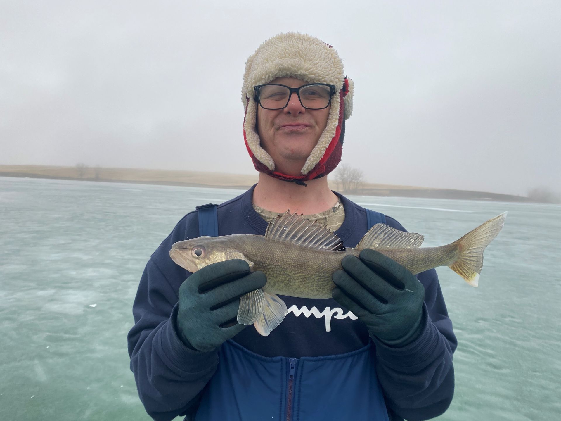 a man in a champion shirt is holding a fish in his hands.